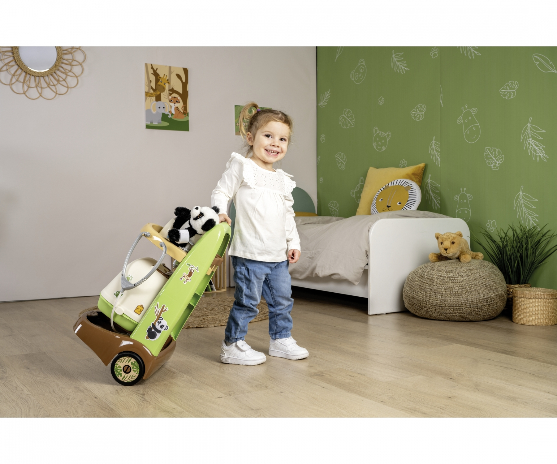 Ein kleines Mädchen zieht einen Spielzeug-Staubsauger mit Panda und Spielzeug.