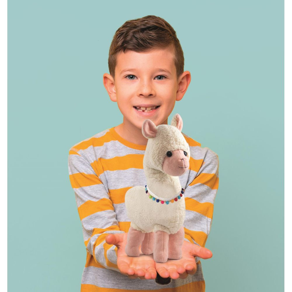Un bambino tiene un alpaca di peluche bianco con collana di perline.
