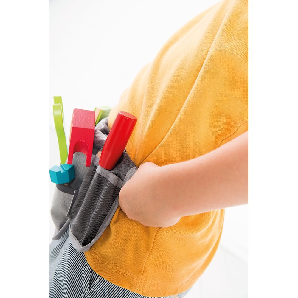 Kind mit Werkzeuggürtel, gelbes Hemd, Streifenhose, Holzspielzeug.