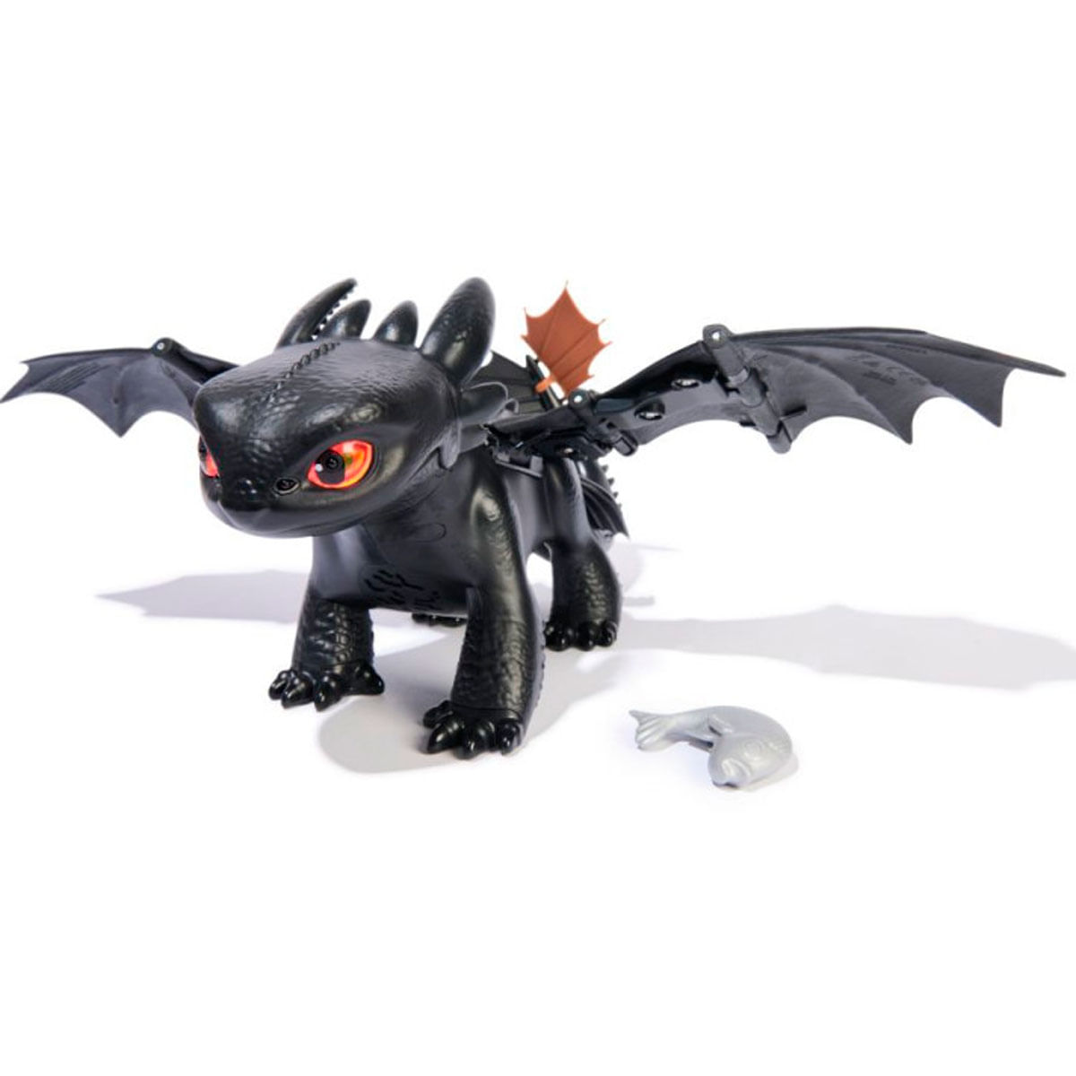 Jouet dragon noir aux yeux rouges et ailes, à côté d'un poisson.