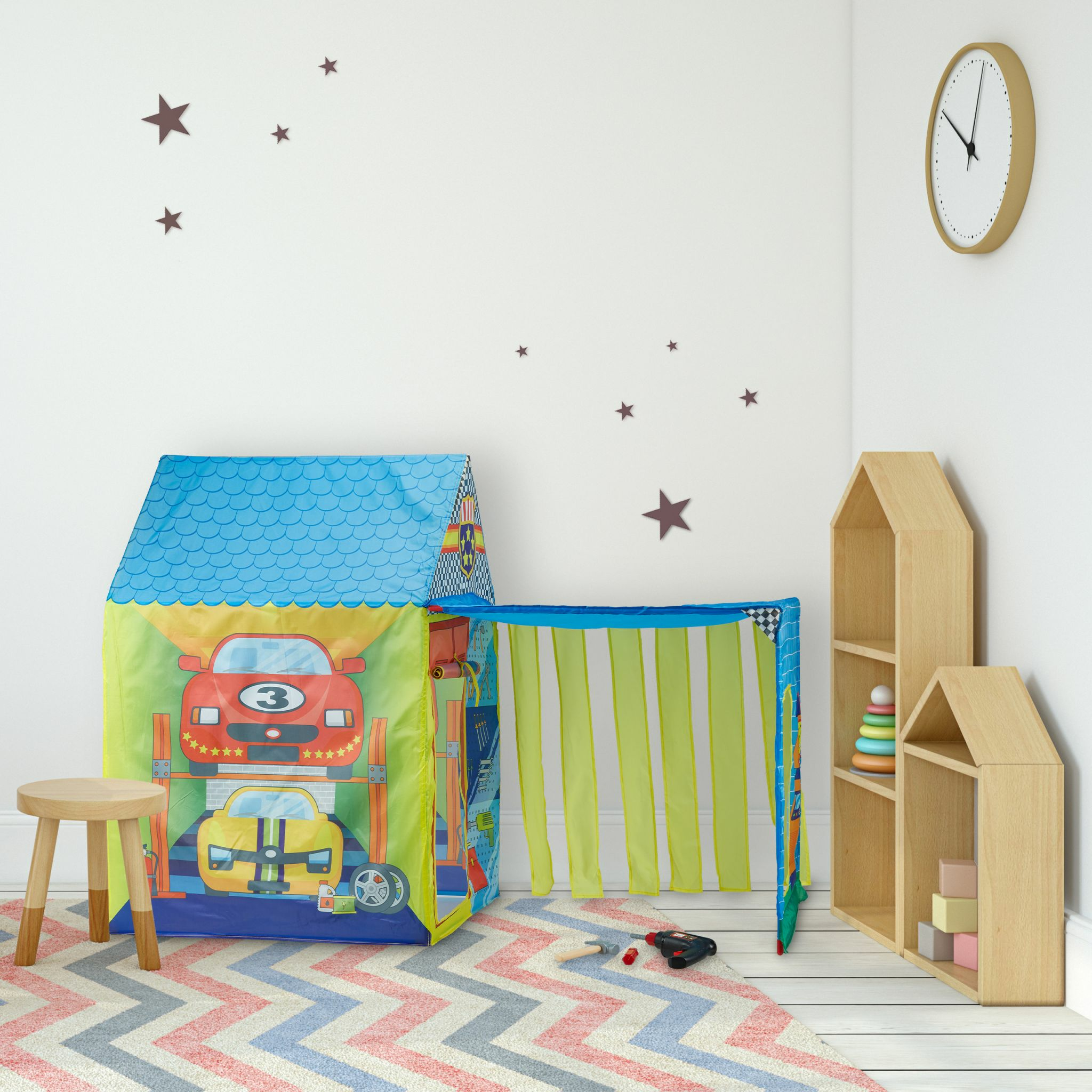 Kinderzelt mit Autoprint, Holzstuhl, Spielzeug und Uhr an der Wand.