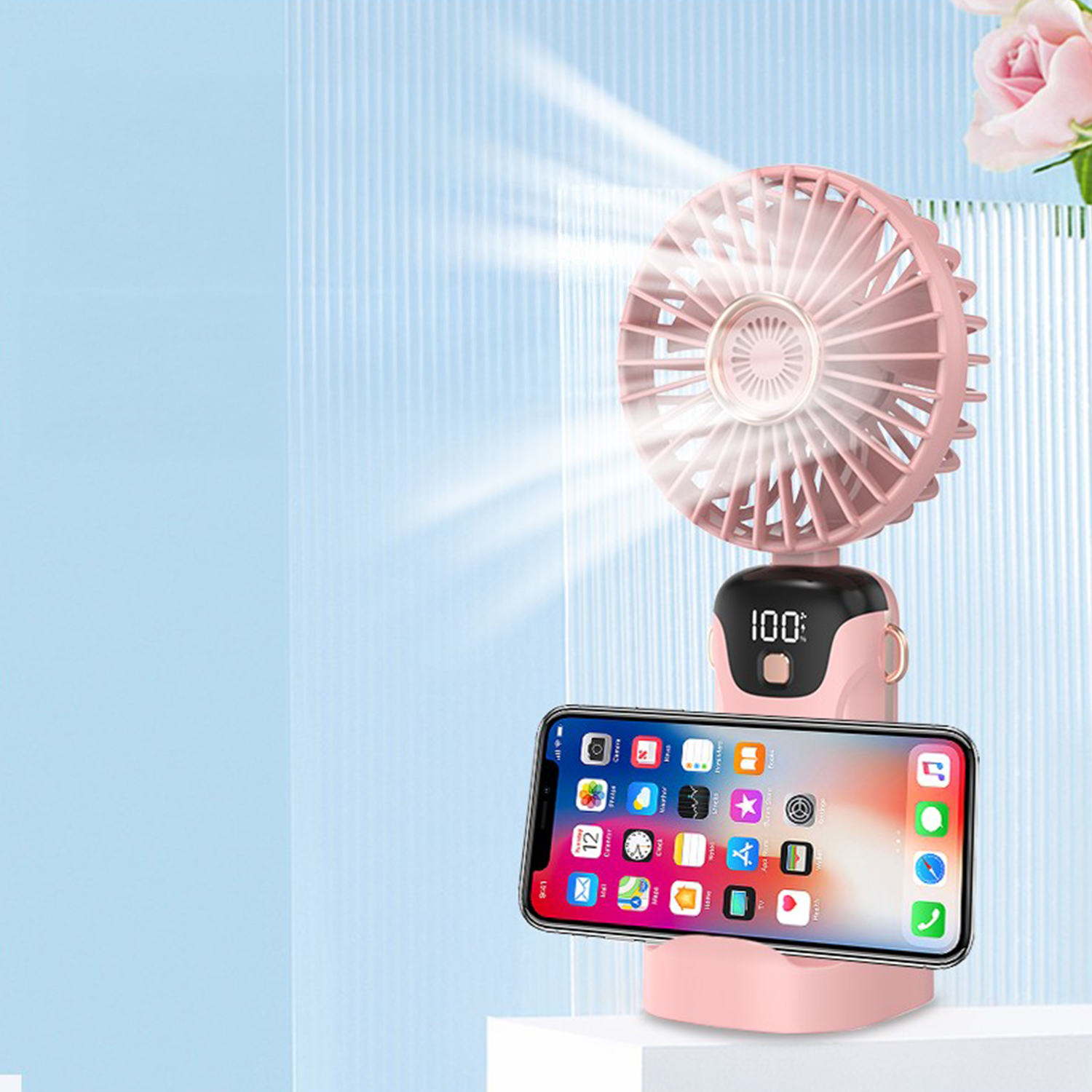 Un ventilatore rosa con un supporto per telefono che tiene uno smartphone.
