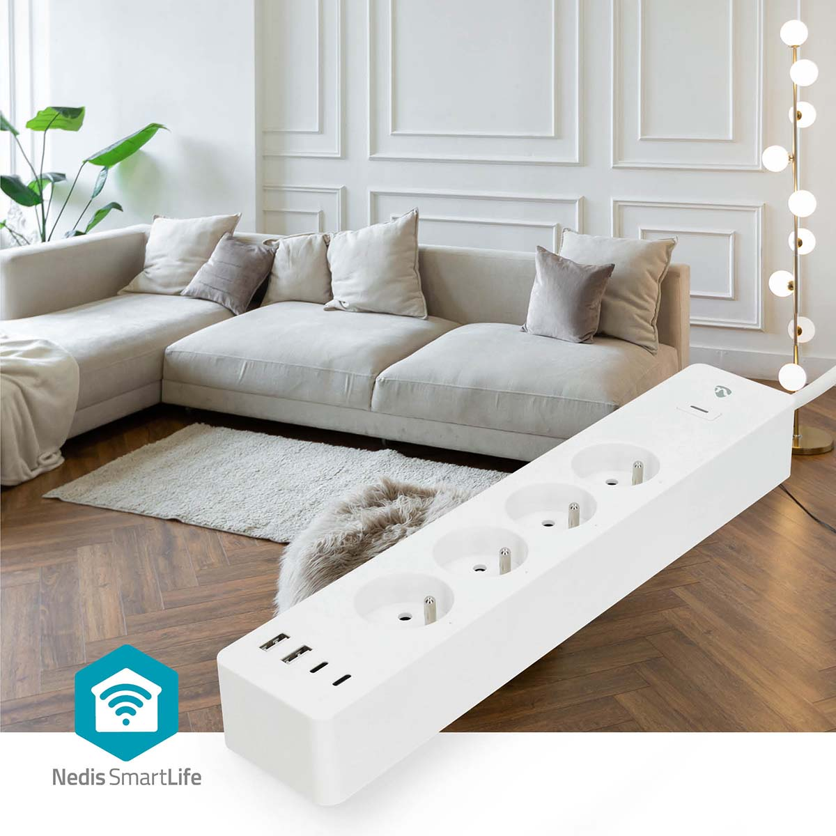 Multipresa bianca con 3 prese e porte USB su pavimento in legno, vicino a un divano.