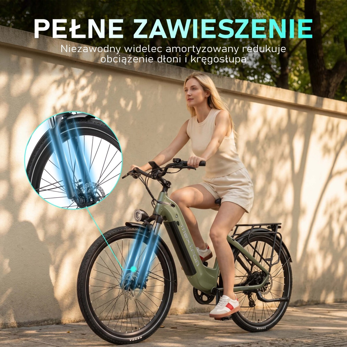 Kobieta jedzie na zielonym rowerze elektrycznym z amortyzowanym widelcem.