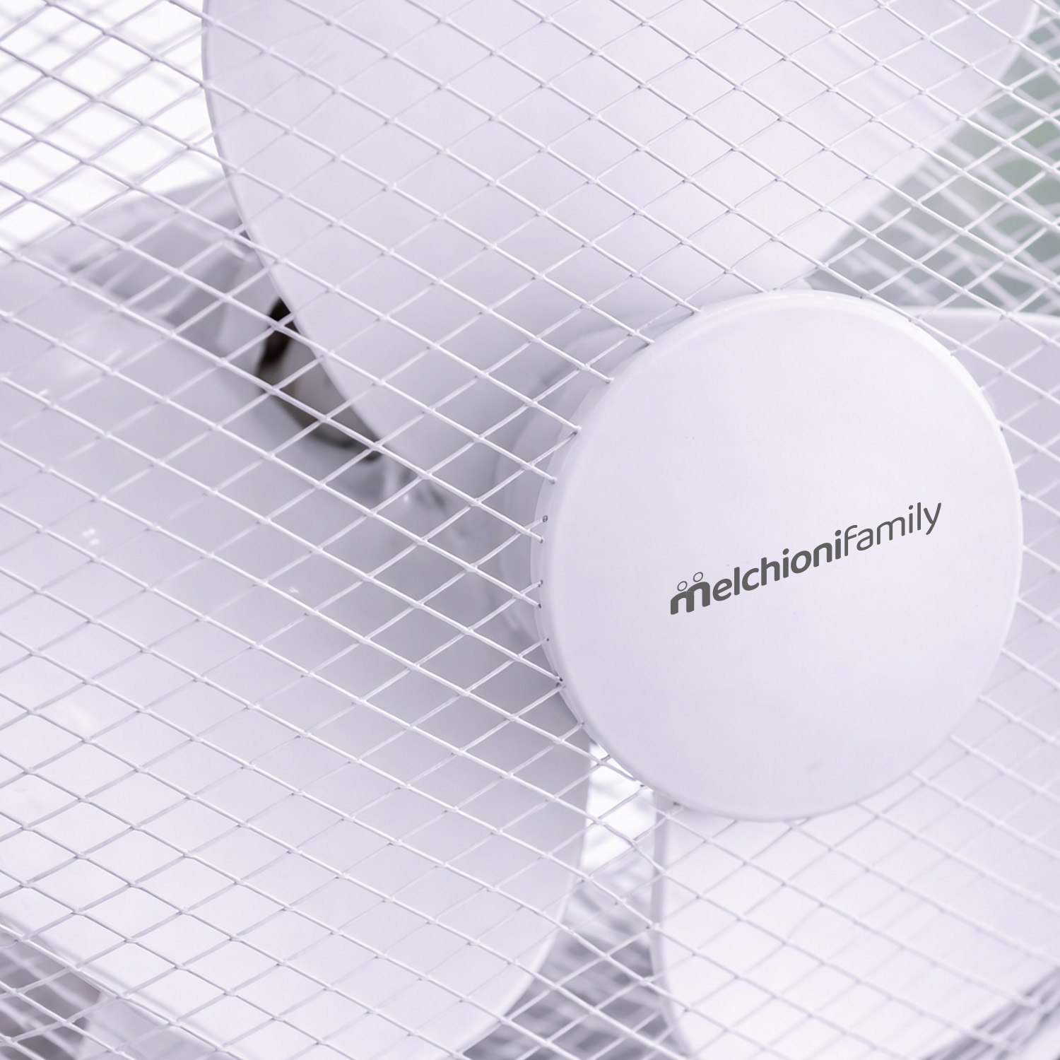 Primer plano de un ventilador blanco con el logo 'melchionifamily'.