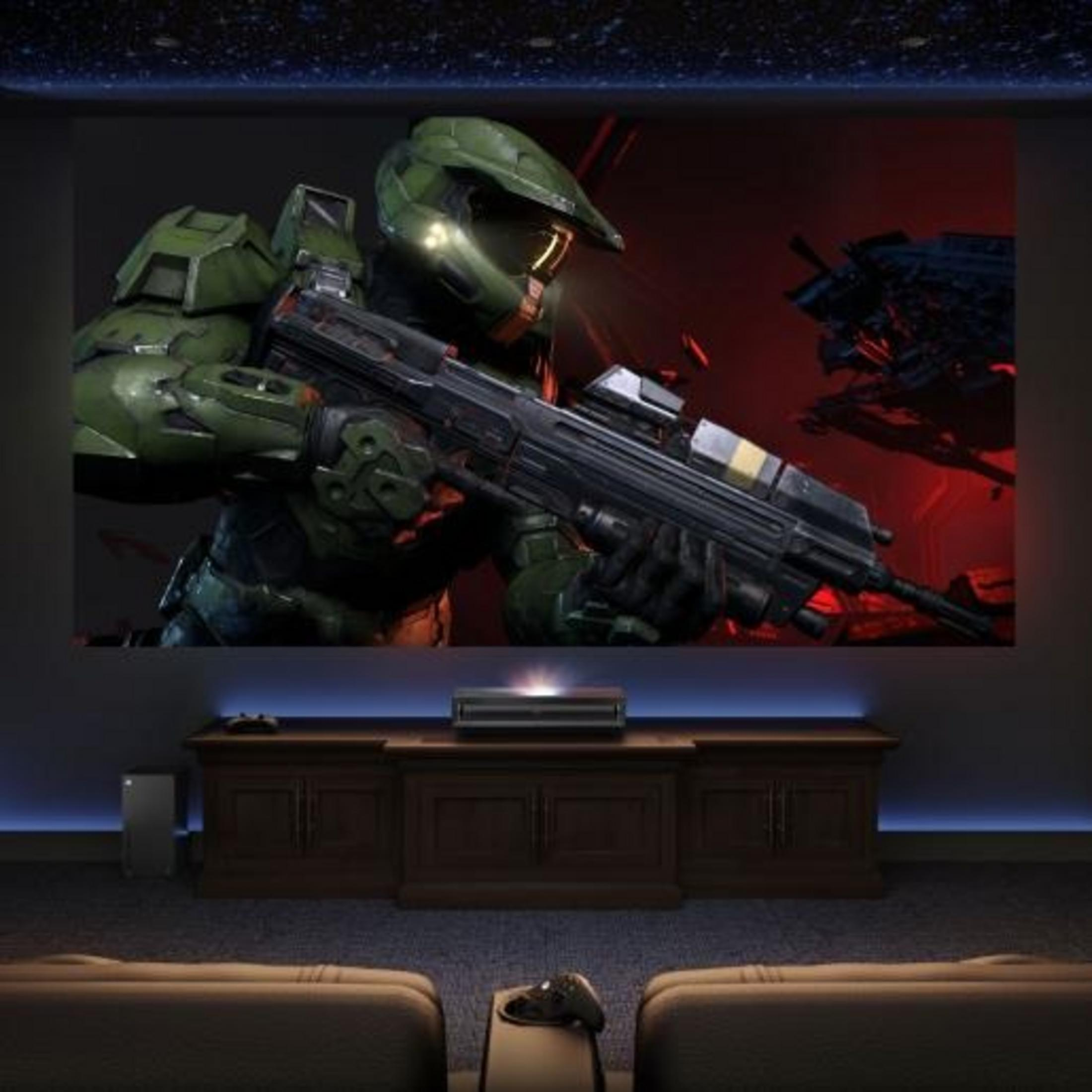 Master Chief w zielonej zbroi trzyma broń, na czerwonym tle.