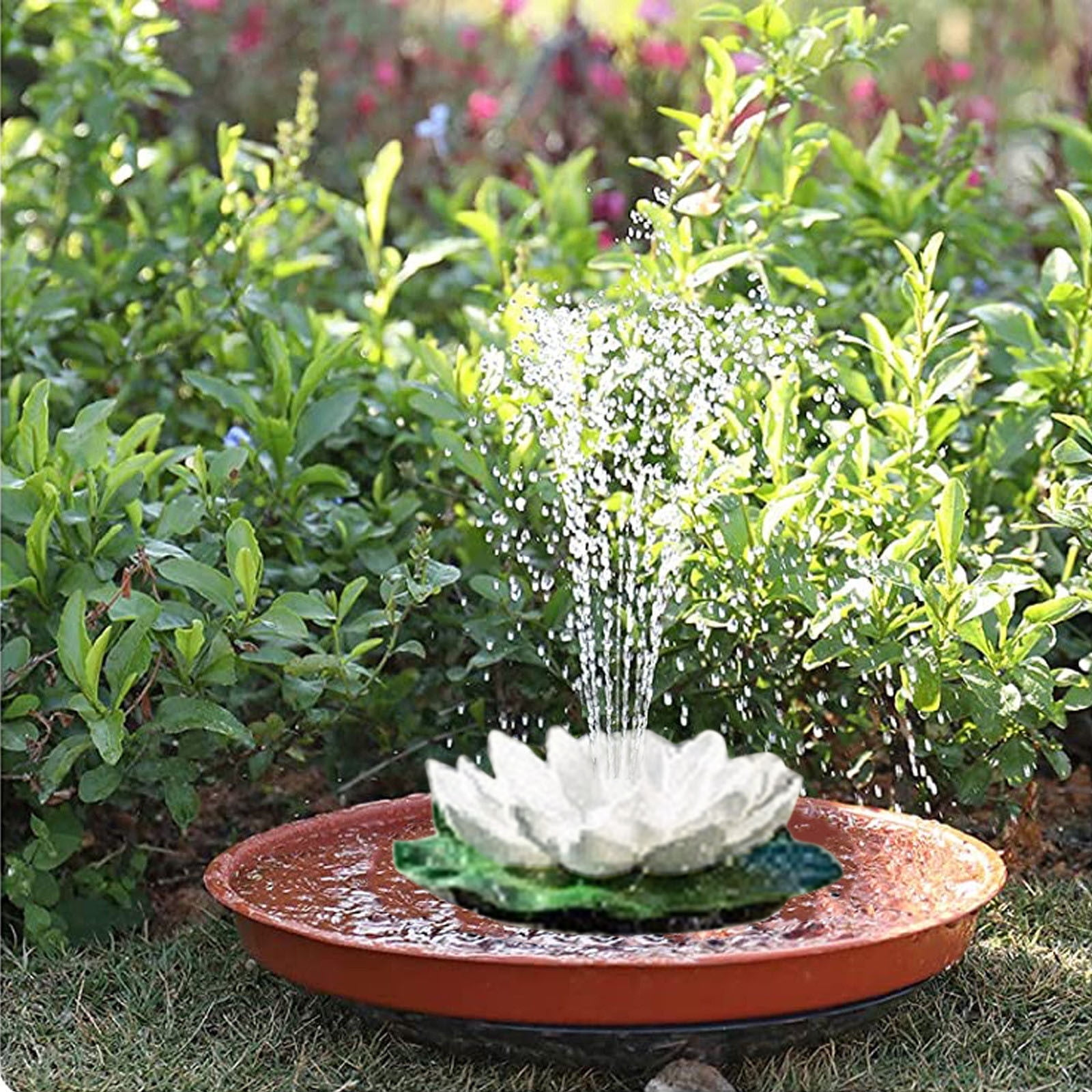 Ein weißer Lotosblumenbrunnen mit einem Wasserstrahl im Garten.