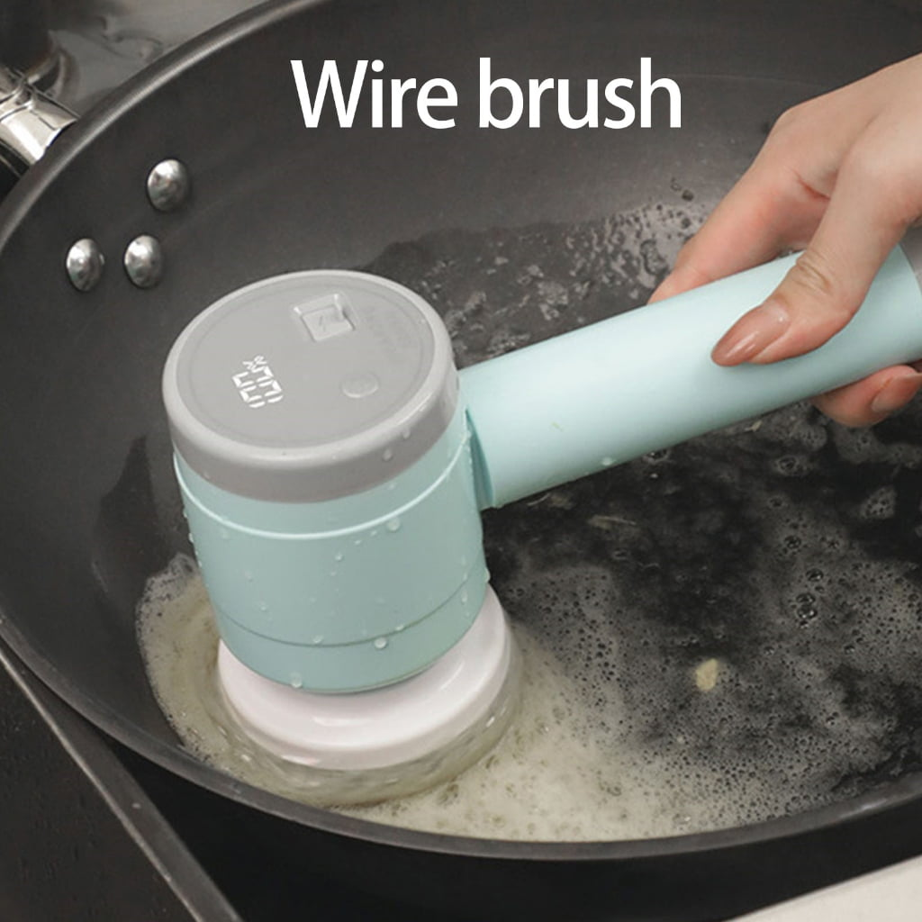 Eine Hand hält eine elektrische Bürste, die eine Pfanne mit schaumigem Wasser reinigt.