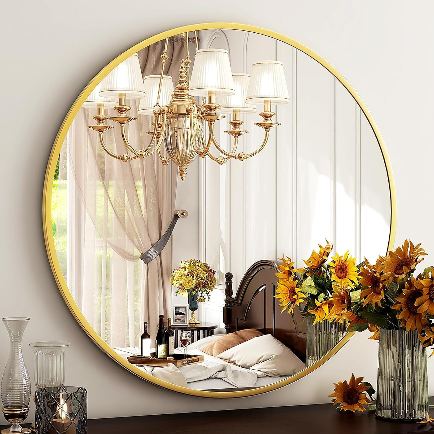Ein runder Spiegel mit goldenem Rahmen spiegelt ein Schlafzimmer mit Bett und Blumen wider.