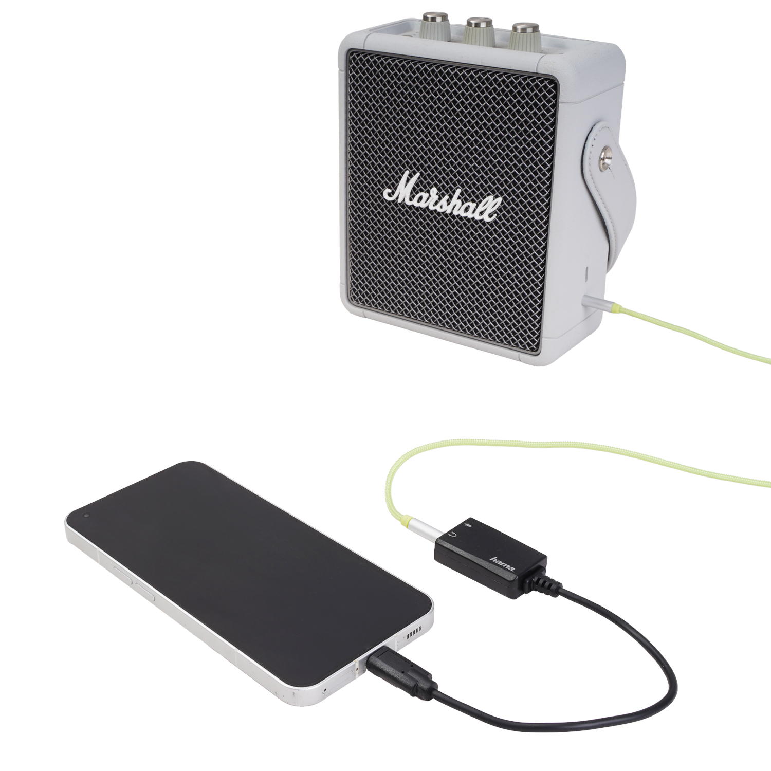 Ein Marshall-Lautsprecher ist mit einem Smartphone über einen Adapter verbunden.