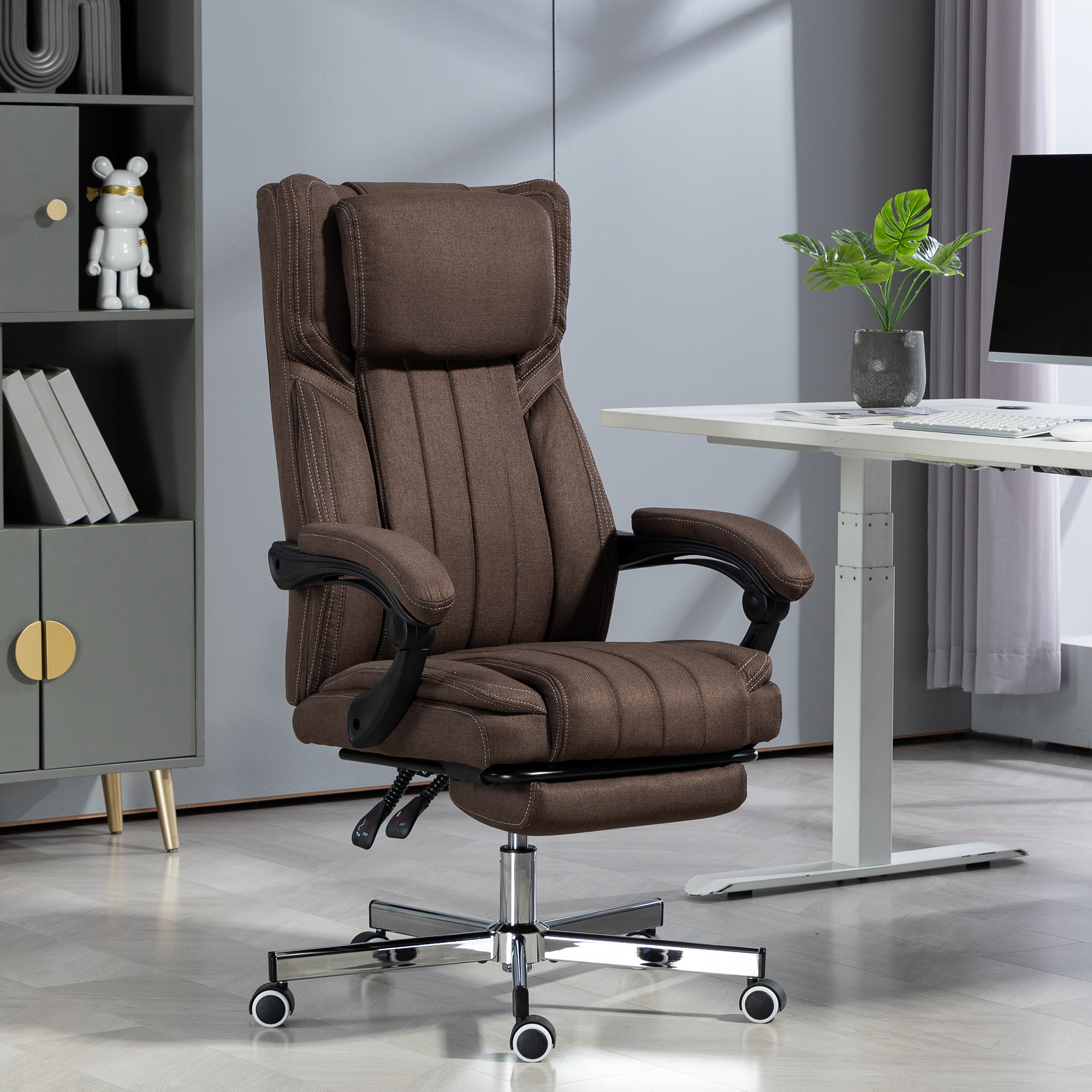 Una silla de oficina marrón con reposapiés está delante de un escritorio.
