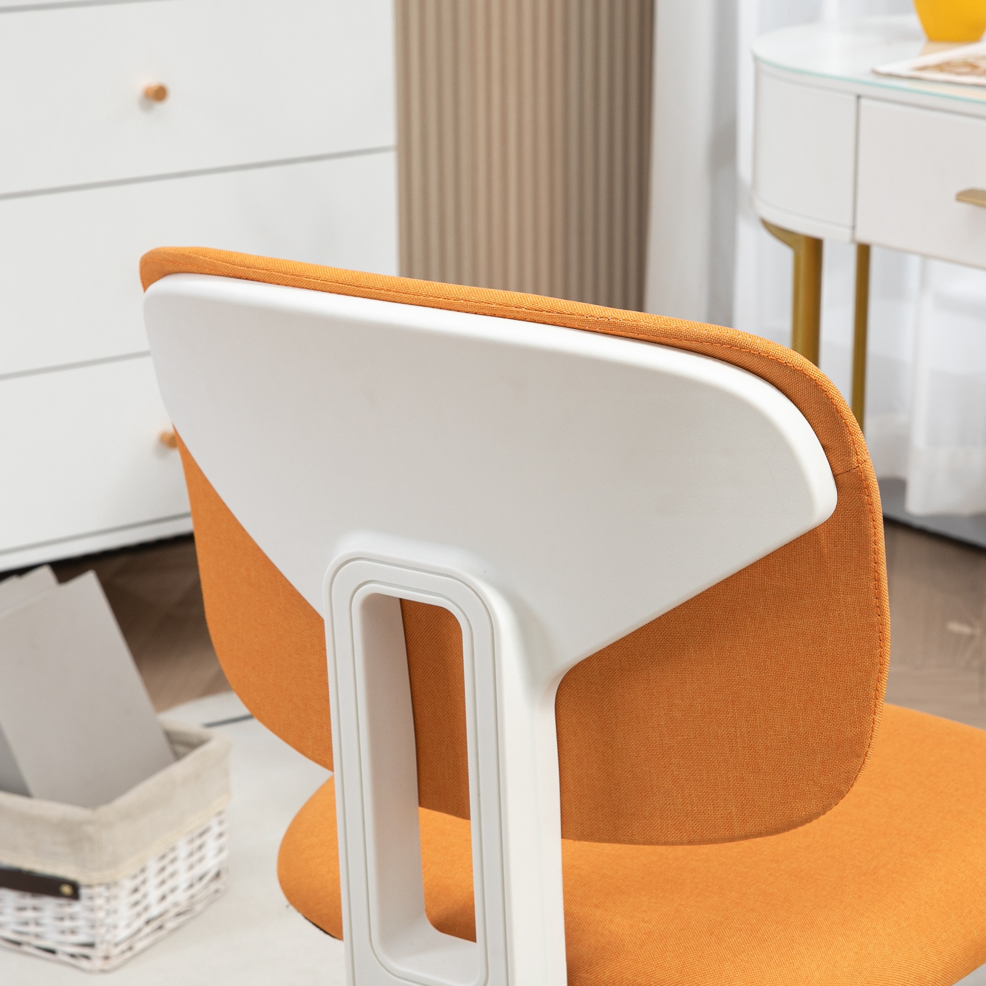 Primer plano de una silla naranja con respaldo y asa blancos.