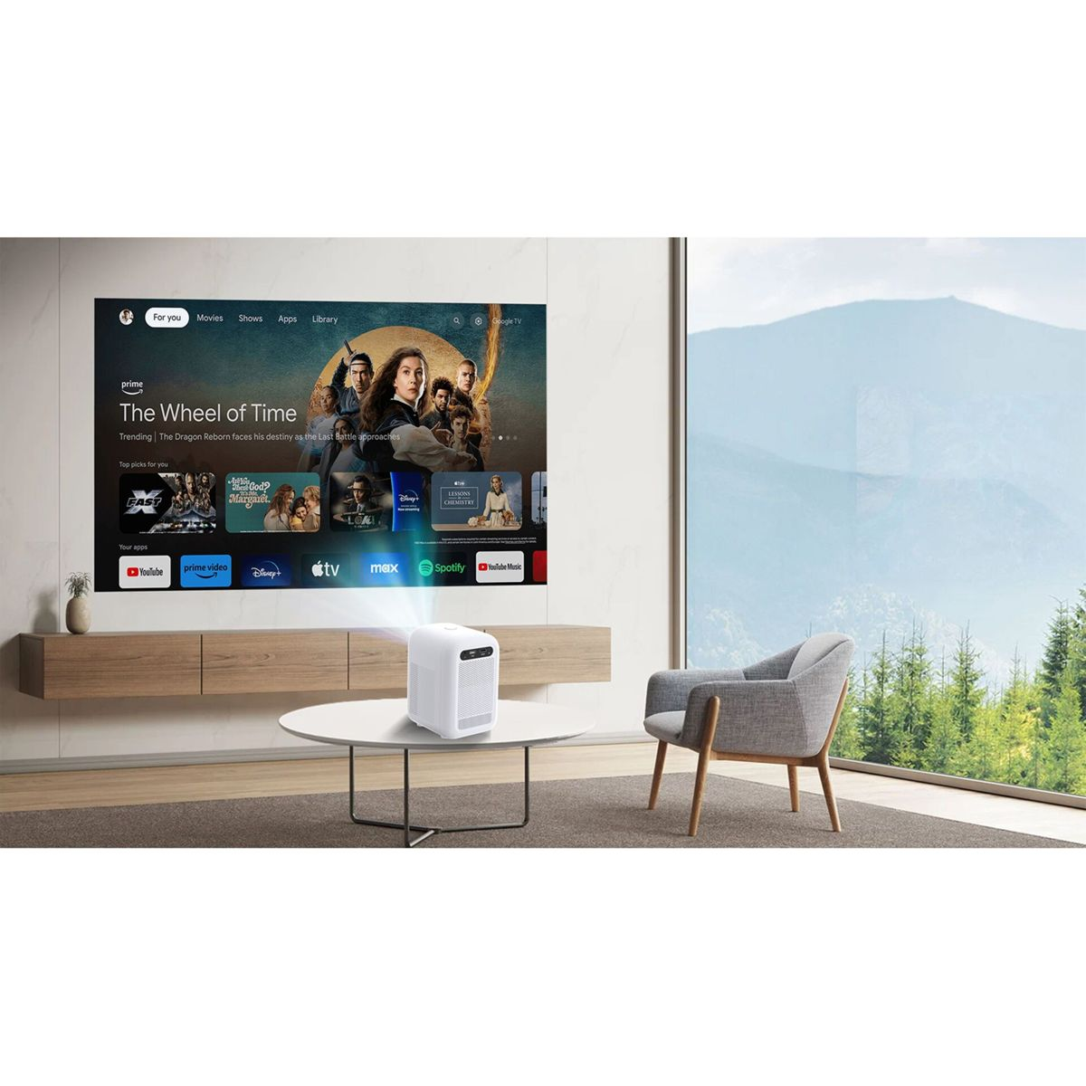 Ein weißer Projektor projiziert ein Bild auf einen großen Bildschirm mit Streaming-Apps. Ein Sessel steht daneben.