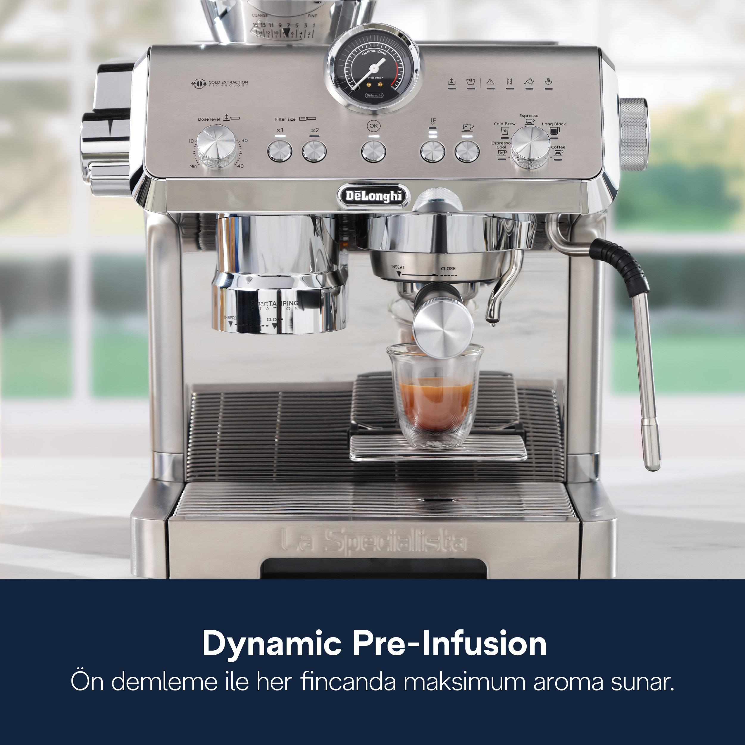 Gümüş DeLonghi espresso makinesi, bir bardak espresso ve basınç göstergesi ile.
