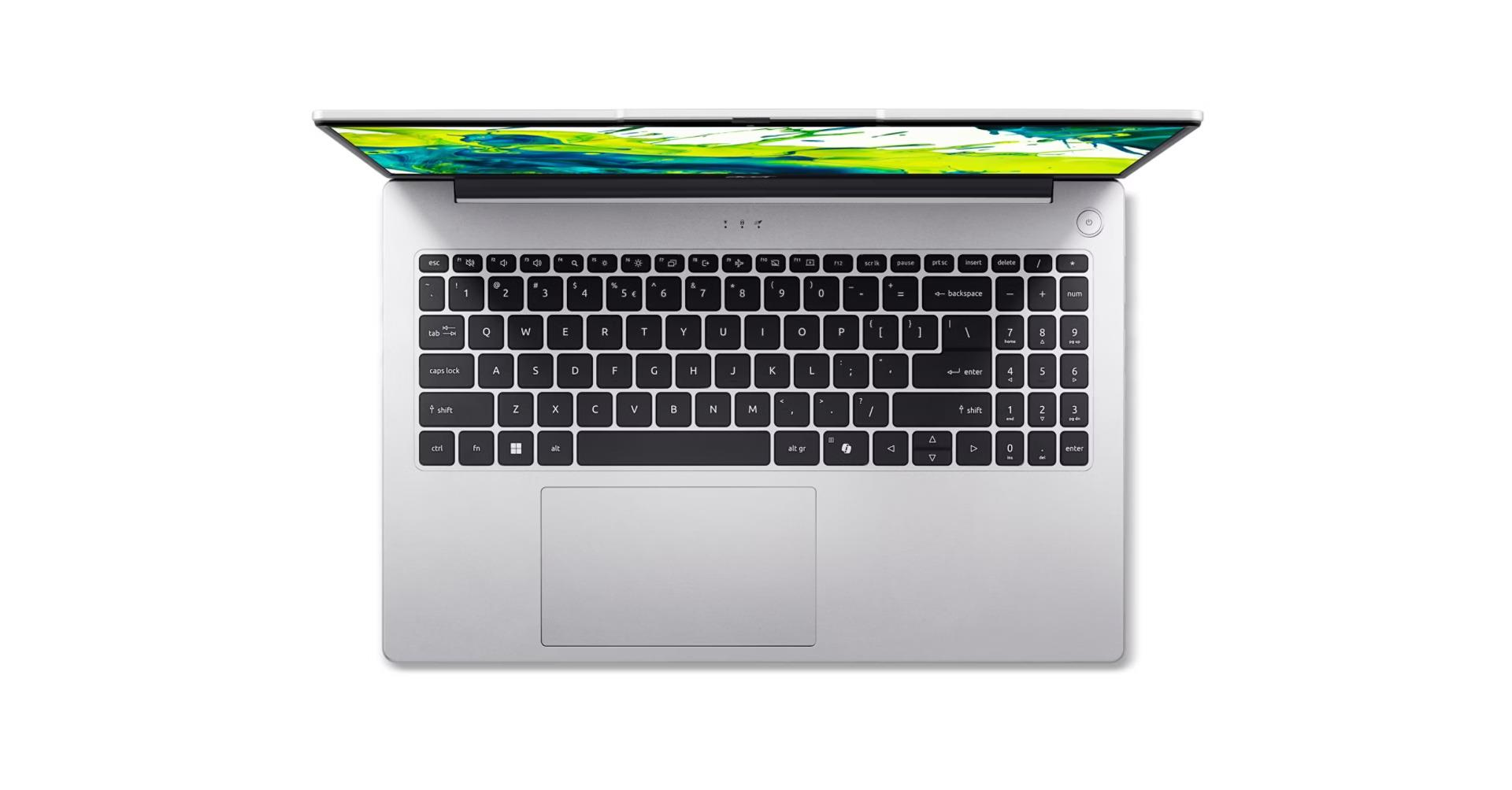 Gümüş rengi laptop, üstten açık, aydınlatmalı ekranı ve klavyesiyle.