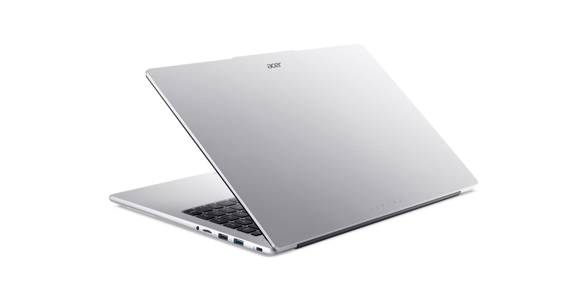 Gümüş renkli Acer dizüstü bilgisayar açık, klavyesi ve portları beyaz zeminde görünüyor.