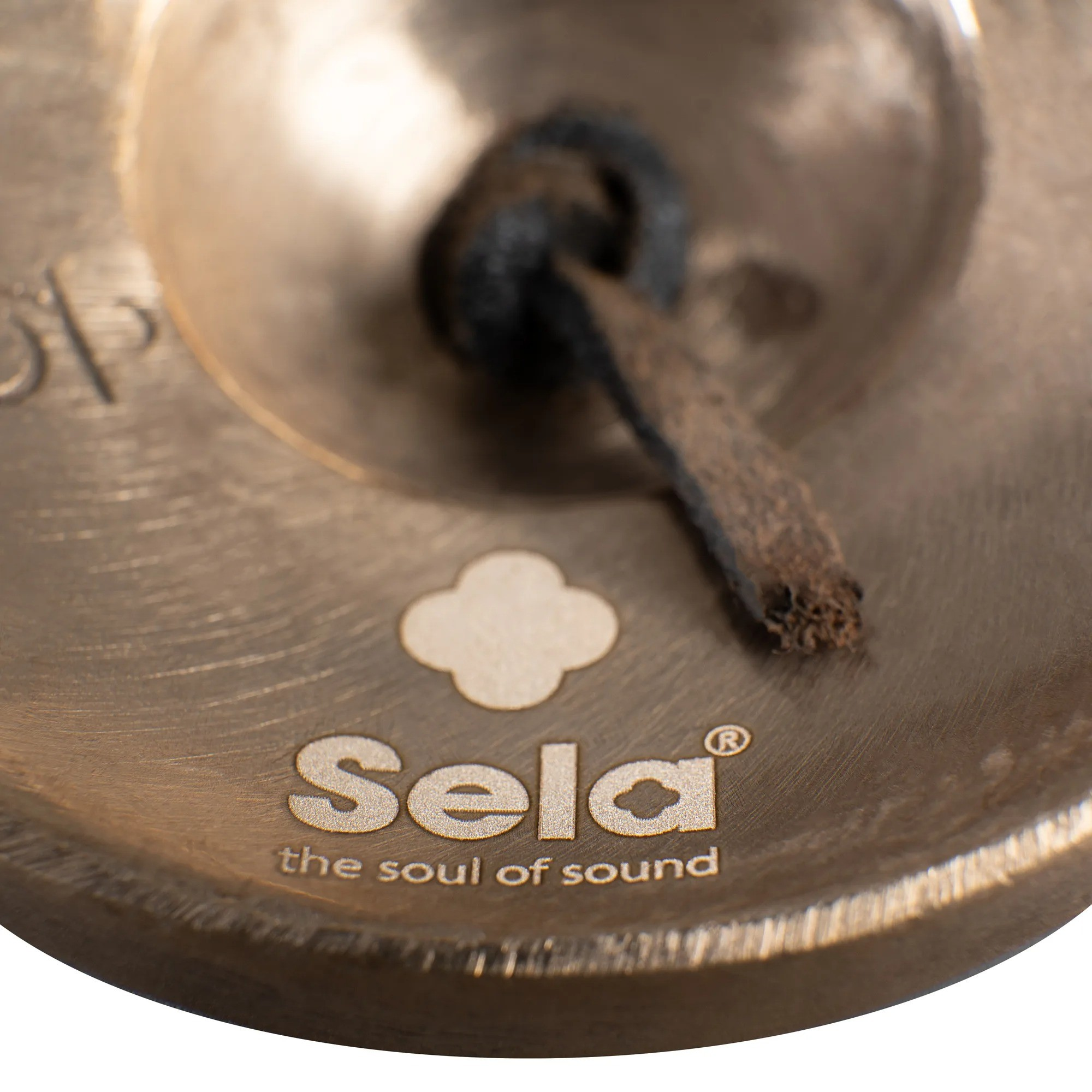 Sela logosu ve 'the soul of sound' yazılı bronz zil yakın çekim.