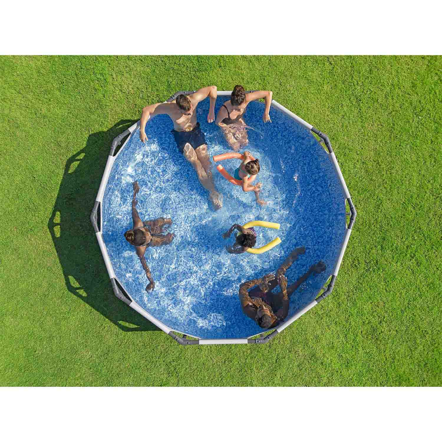 Pięć osób pływa w okrągłym basenie na zielonym trawniku. Dwie używają makaronów.