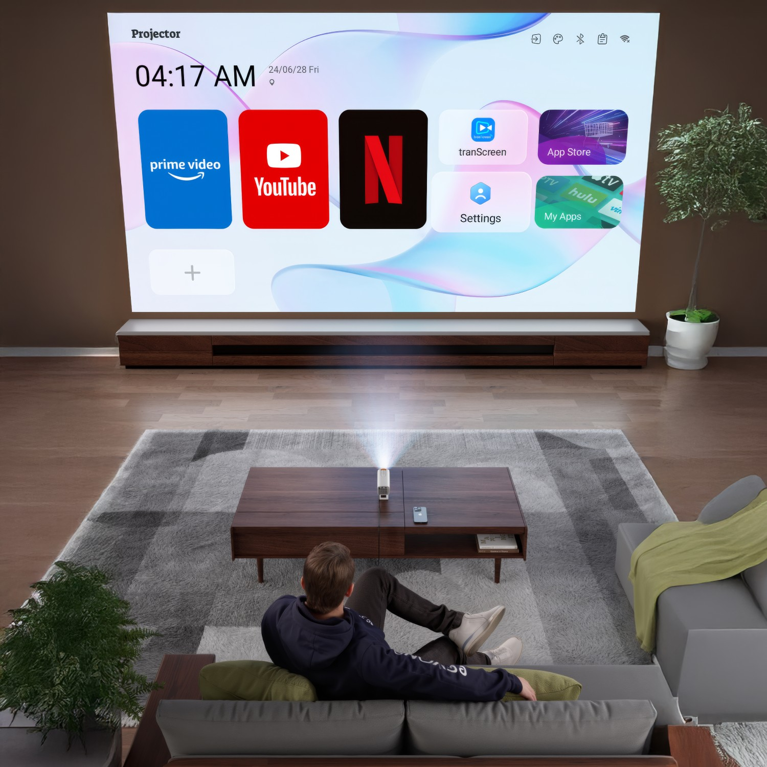 Ekran projektora wyświetla aplikacje: Prime Video, YouTube, Netflix, tranScreen, App Store, Ustawienia, Moje aplikacje.