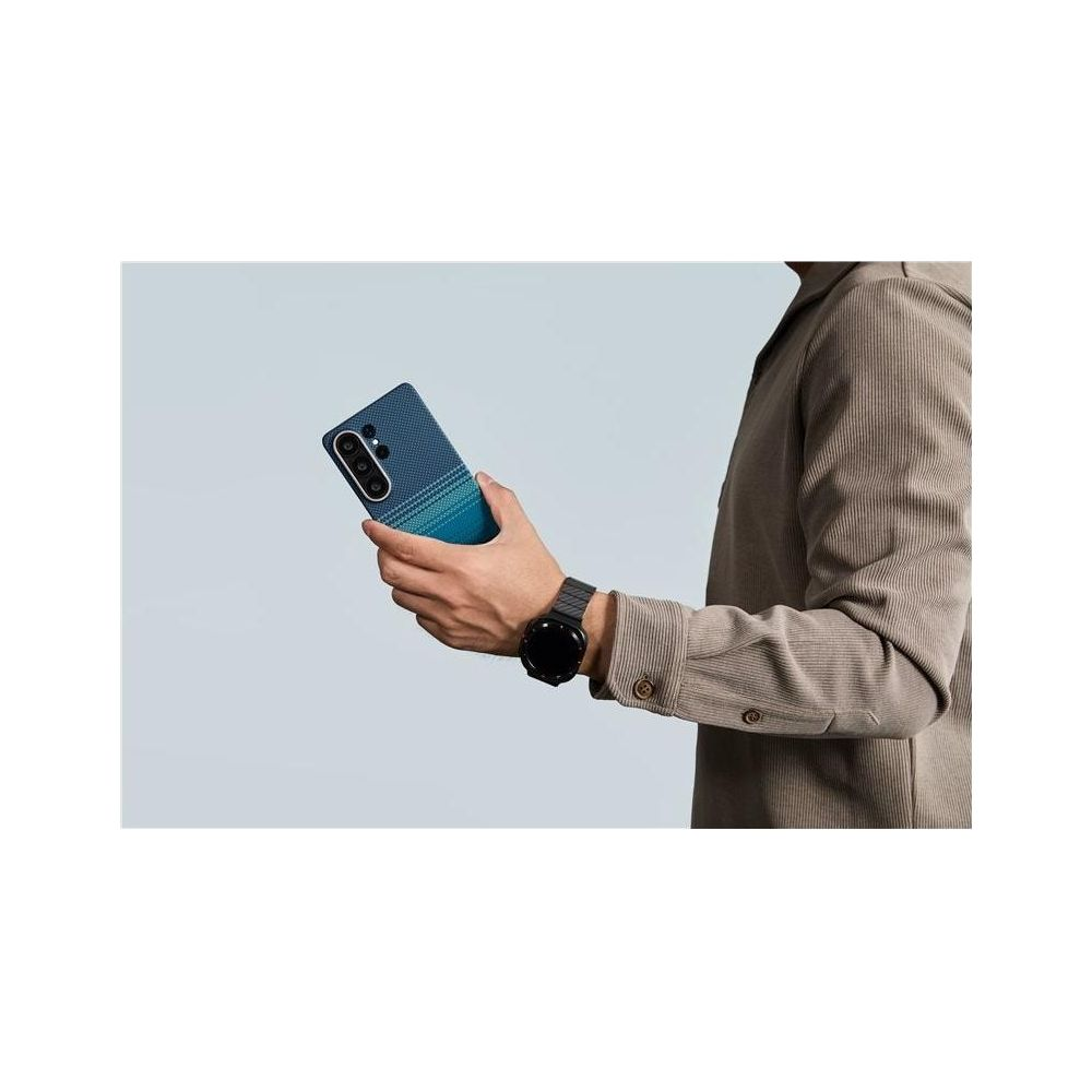 Persona sostiene un teléfono azul con cámaras y un degradado.