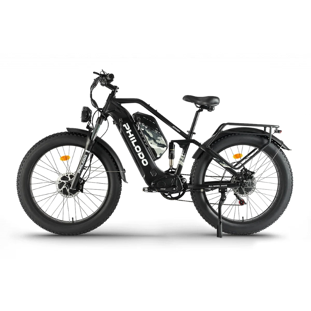 Bicicleta eléctrica negra con neumáticos anchos, suspensión y faro delantero.