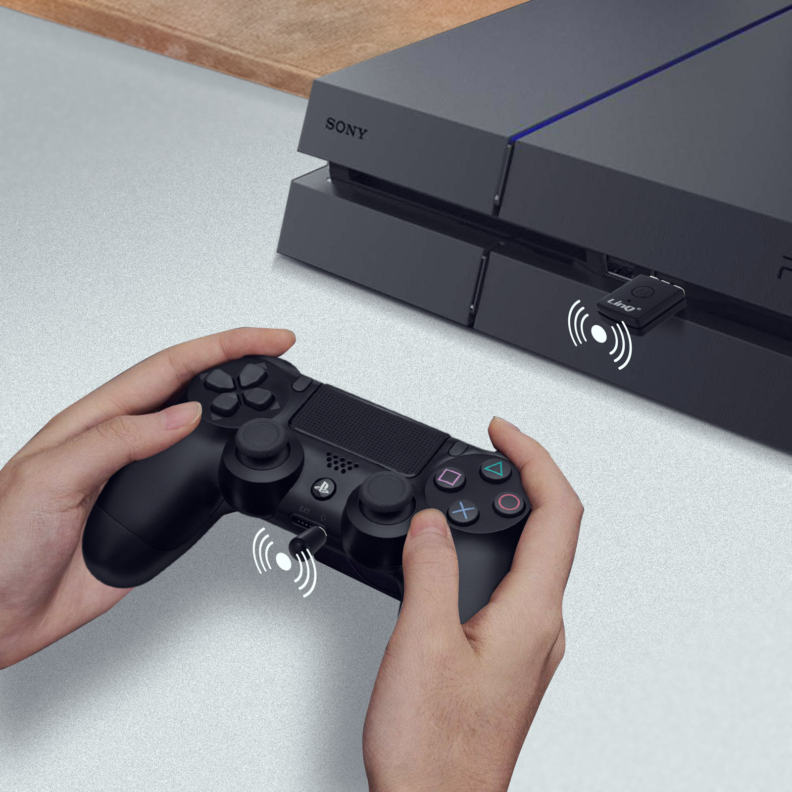 Mani tengono controller PS4 nero vicino console Sony con adattatore wireless.