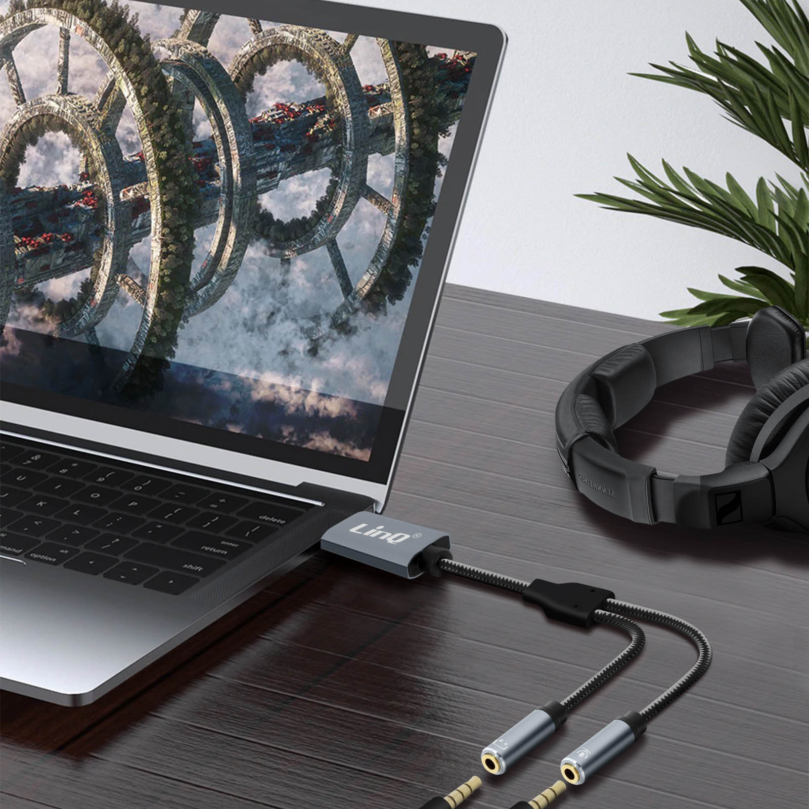 Laptop con cuffie e splitter, immagine futuristica sullo schermo.