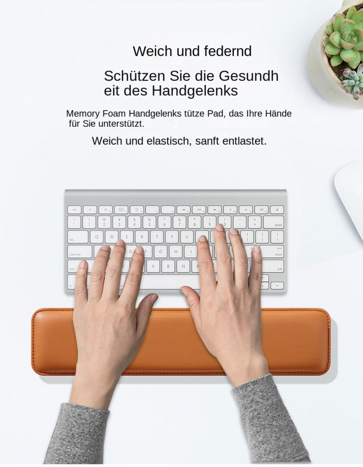 Hände tippen auf Tastatur, Handgelenk ruht auf braunem Pad.