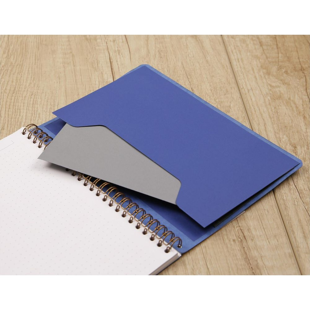 Blauer Umschlag über einem Notizbuch mit Spiralbindung auf Holz.
