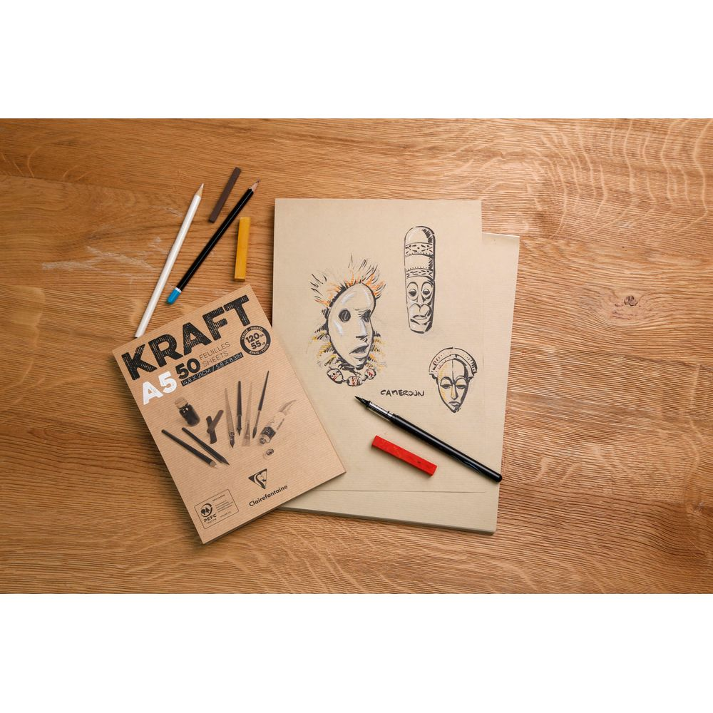 A5 Kraftpapierblock mit Skizzen von afrikanischen Masken, Bleistiften, Kreide und Stiften auf Holz.