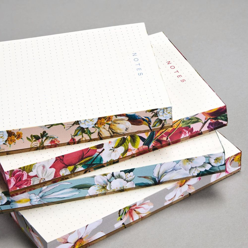 Mehrere Notizbücher mit gepunkteten Seiten und Blumenmustern.