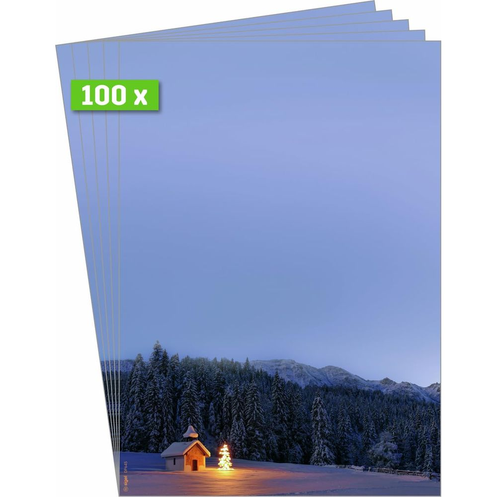 Winterlandschaft mit Kapelle und Weihnachtsbaum vor verschneitem Wald und Bergen.