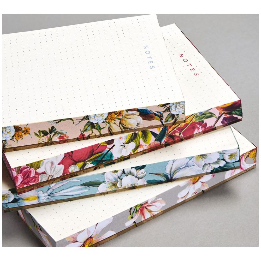 Drei Notizbücher mit gepunkteten Seiten und Blumenrand.