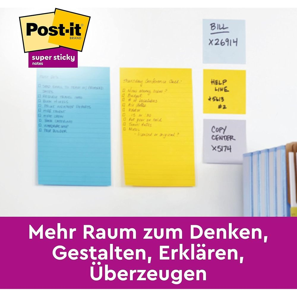 Post-it Notizen in Blau, Gelb und Hellblau haften an einer Wand. Text ist sichtbar.