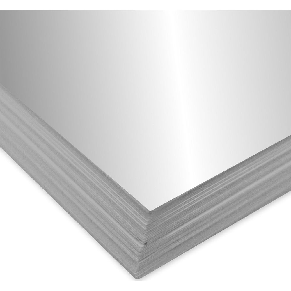 Une pile de feuilles argentées brillantes repose sur un fond blanc.