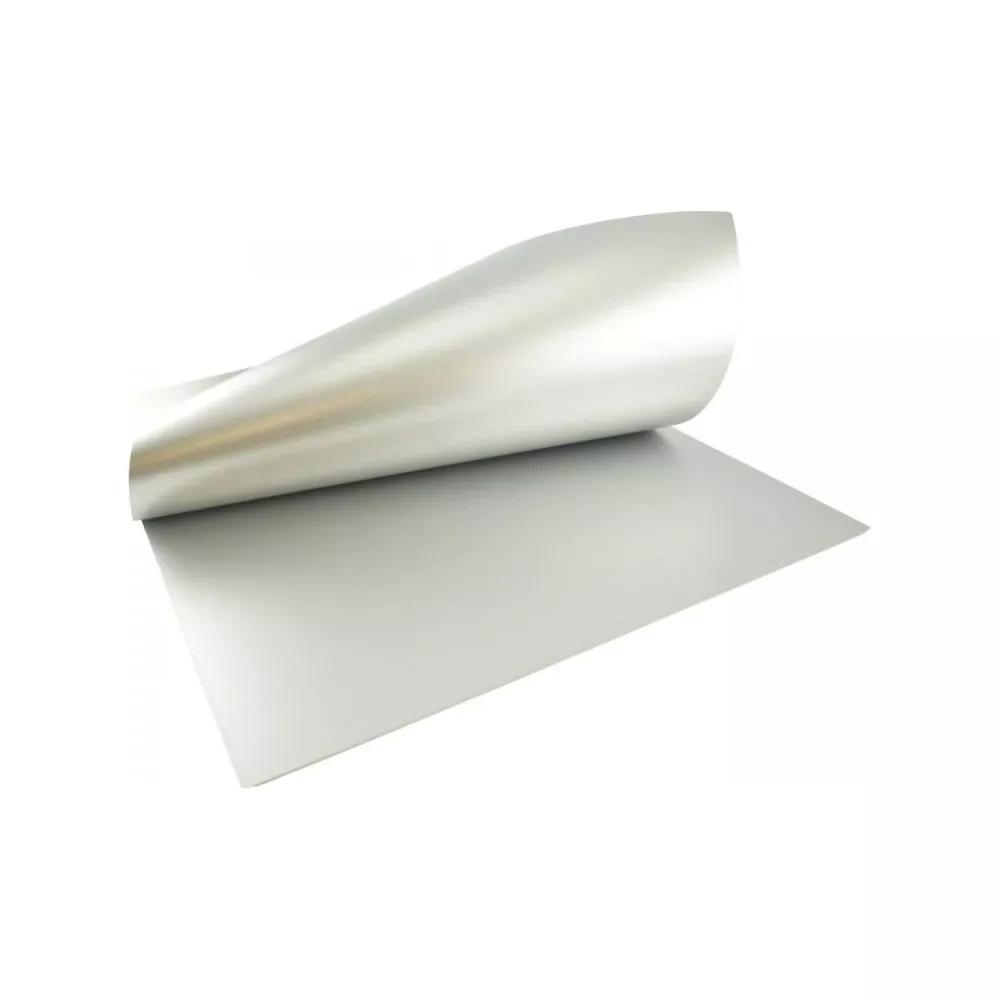 Une feuille de papier argentée repose sur une surface blanche, un coin est relevé.