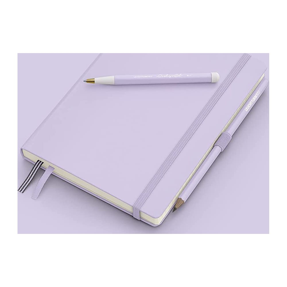 Ein lila Notizbuch mit einem Stift und Bleistift auf einer lila Oberfläche.