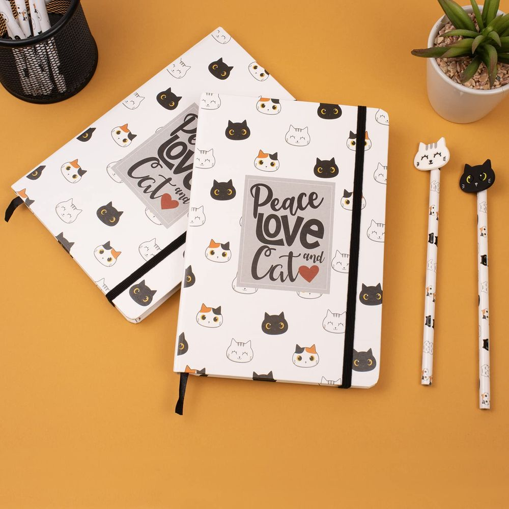 Zwei Notizbücher mit Katzenmotiven und Stifte auf orangefarbenem Hintergrund.