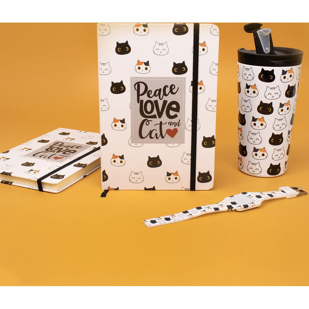 Ein Notizbuch, ein Becher und ein Armband mit Katzenmotiv auf gelbem Hintergrund.