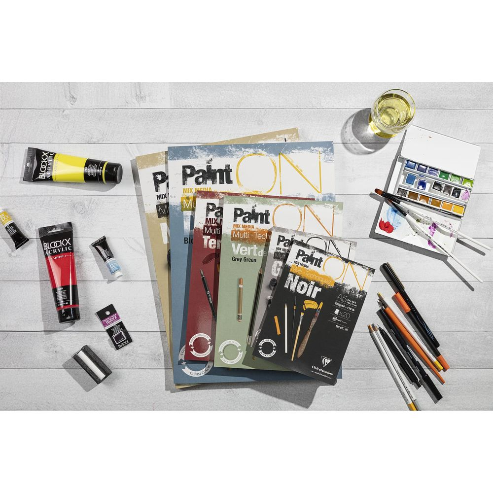 Materiali artistici con colori, penne e carta su sfondo di legno.