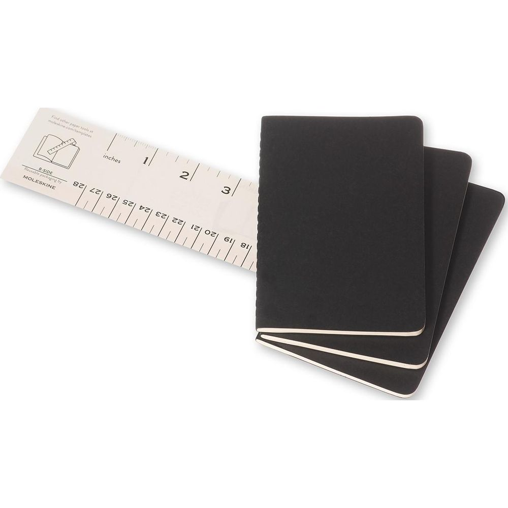 Drei schwarze Moleskine Notizbücher liegen neben einem Lineal mit Zoll- und Zentimeterangaben.