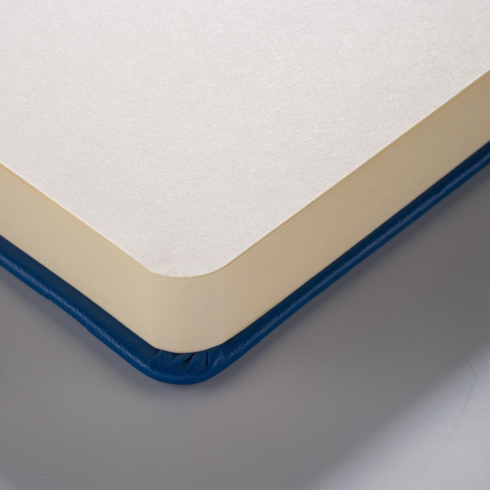Gros plan d'un carnet bleu avec des pages blanches.
