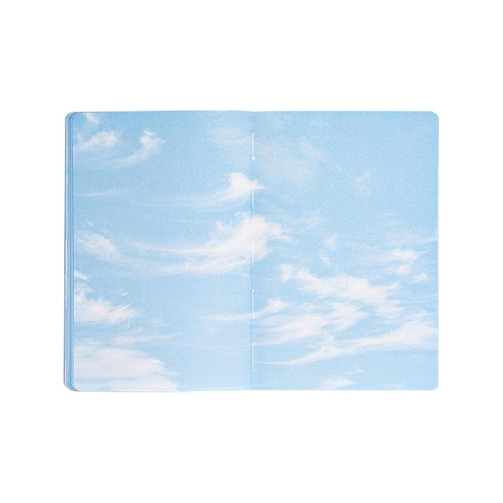 Un carnet ouvert orné d'un motif ciel bleu et nuages.