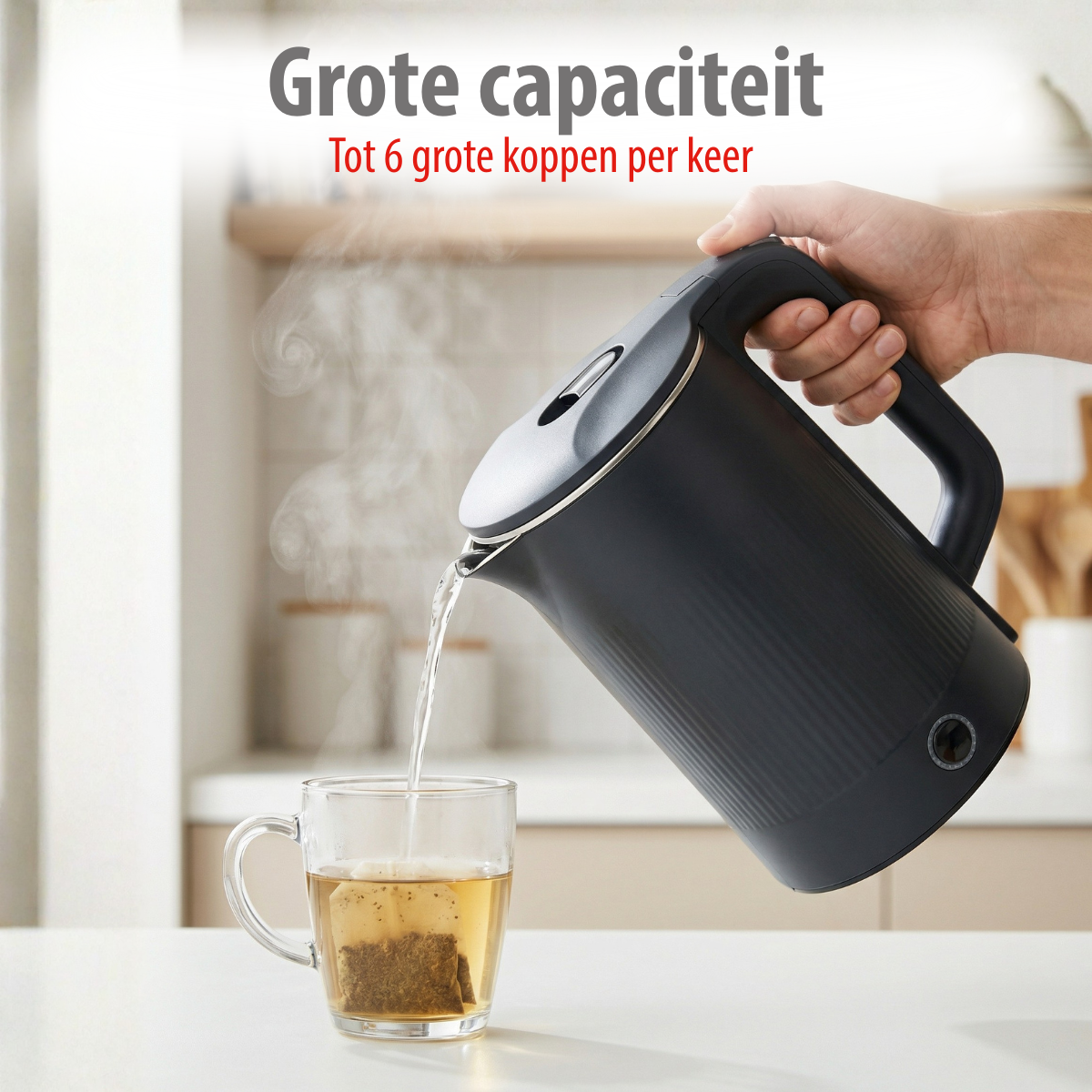 Une main tient une bouilloire noire, versant de l'eau chaude dans une tasse en verre avec un sachet de thé.