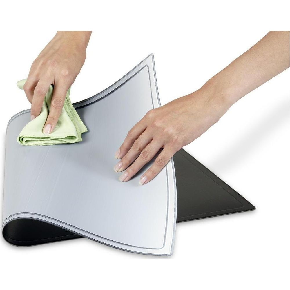 Des mains nettoient un set de table argenté avec un chiffon vert.