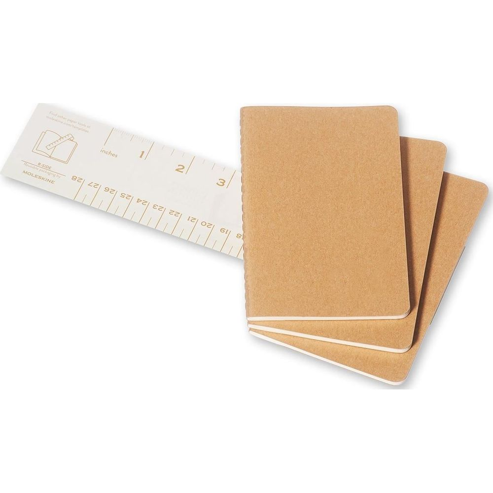 Trois carnets marron à côté d'une règle graduée en pouces et en centimètres.