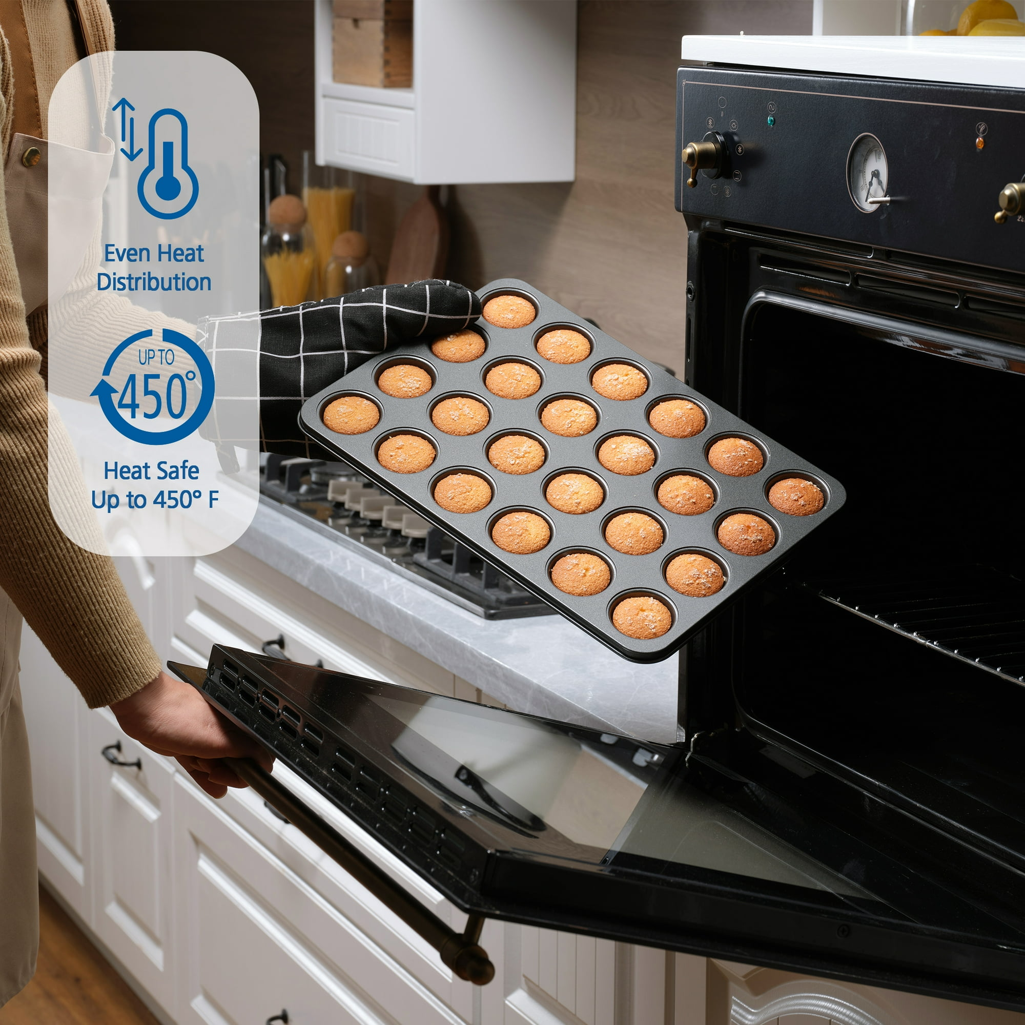 Ein Backblech mit 20 Muffins wird aus einem Ofen genommen. Der Ofen ist geöffnet.