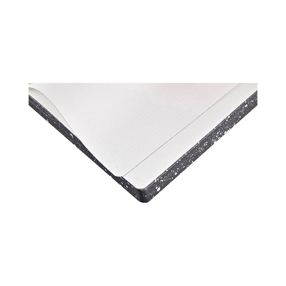 Gros plan d'un carnet ouvert avec des pages pointillées et une couverture noire tachetée.