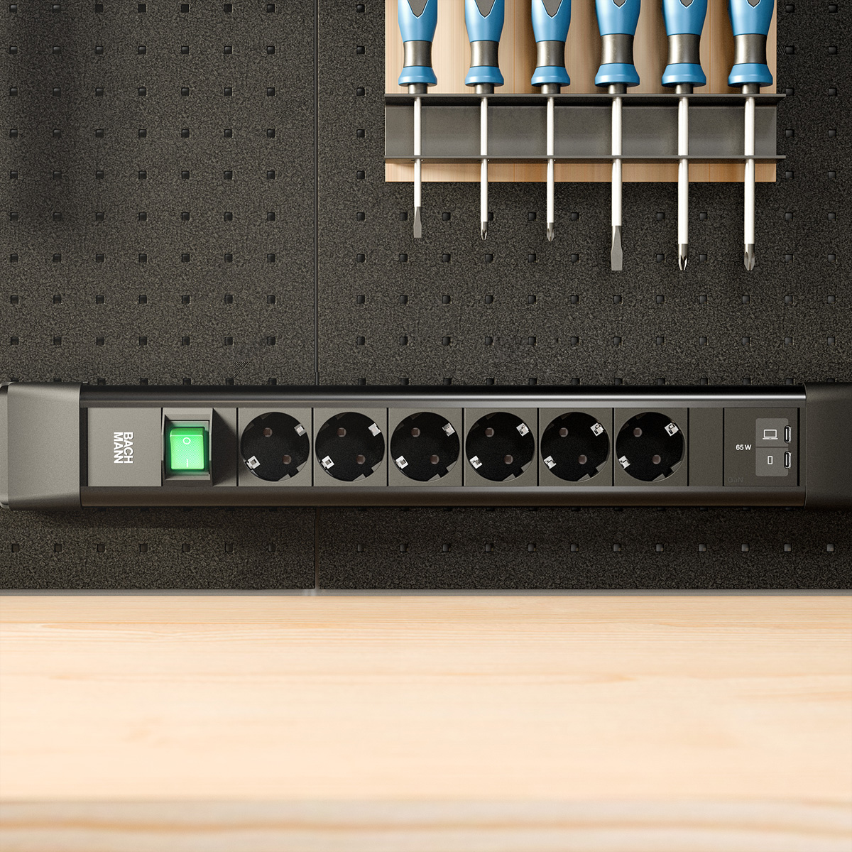 Schwarze Steckdosenleiste mit grünem Schalter, Steckdosen und USB-Anschlüssen an Wand.