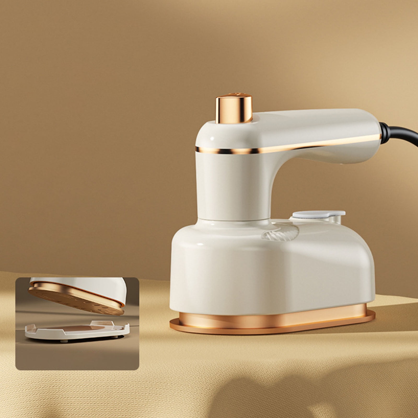 Ein cremefarbener Mini-Dampfbügeleisen mit goldenen Akzenten steht auf einem Tisch.
